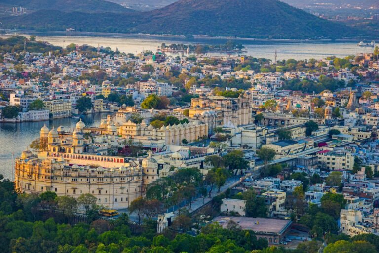 Stunning aerial view of Udaipur City and City Palace featuring scenic landscapes and vibrant architecture.